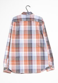 Chemise à manches longues en carreaux orange, marine, blanc et jaune. Tissu doux, poignets à boutons et ourlet arrondi avec une découpe dans le dos.