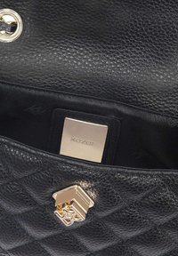 Borsa a mano in pelle nera con texture trapuntata, dotata di una chiusura dorata e di una placca con logo all'interno. L'interno è rivestito in tessuto nero.