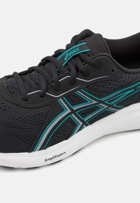 Zwarte sportieve schoen met een bovenwerk van mesh, turquoise accenten, witte details en AmpliFoam+ branding op de tussenzool. Vetersluiting.