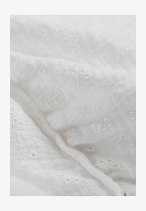 Witte geborduurde stof met bloemmotieven en een fijne textuur, met kleine gaatjesdetails en een delicate, zachte uitstraling.