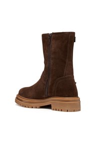 Bottines en daim marron avec une finition lisse, fermeture éclair sur le côté, semelle en caoutchouc épaisse et profil texturé pour une meilleure adhérence.