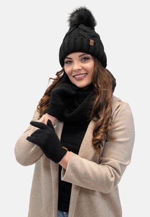Căciulă tricotată neagră cu pompon, fular negru asortat și mănuși fără degete. Textură moale; designul prezintă modele cu nervuri și o etichetă din piele.