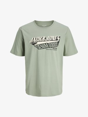 Tricou din bumbac de culoare verde deschis, cu un design grafic în alb și negru care include text. Gât rotund, mâneci scurte și un tiv drept.