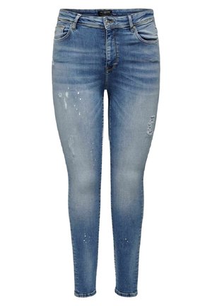 Blaue Skinny-Jeans mit ausgewaschener Wäsche, leichter Beanspruchung und Farbspritzern auf den vorderen Oberschenkeln und unteren Beinen.