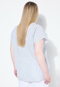 Gestreepte blouse in lichtblauw en wit, korte mouwen, losse pasvorm, met een gestructureerde stof. Heeft zijslits, wat een ontspannen ontwerp benadrukt.