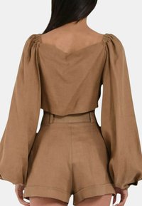 Top cropped in lino marrone con maniche a palloncino e scollatura quadrata, abbinato a pantaloni corti a vita alta in coordinato con una vestibilità sartoriale.