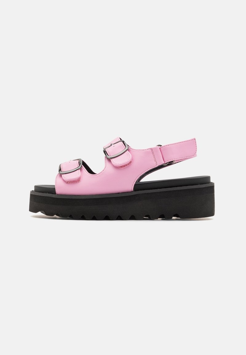 Sandale plateforme en cuir rose avec deux brides réglables à boucle et une semelle noire épaisse à bande adhérente striée.