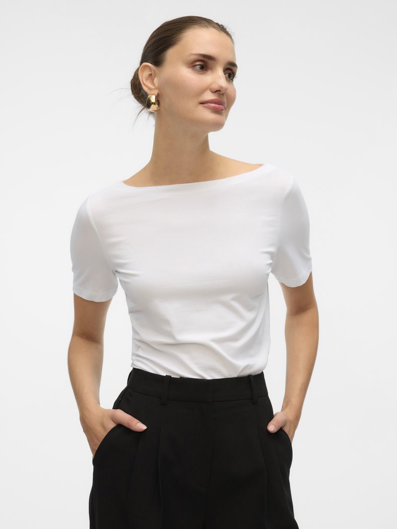 Top bianco a maniche corte con scollo ampio, abbinato a pantaloni neri a vita alta. Texture liscia, design minimal e colori neutri.