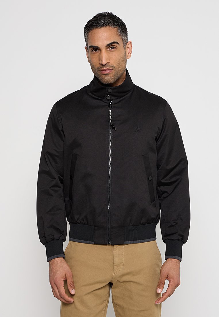 Schwarze Bomberjacke mit hohem Kragen, Reißverschluss und elastischen Bündchen. Glattes, leichtes Material mit Seitentaschen und einem dezenten Logodetail.