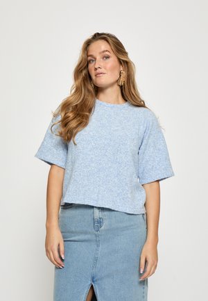 Lys blå cropped sweater med en tekstureret overflade og korte ærmer, parret med en højtaljet denimnederdel med en frontsplit.