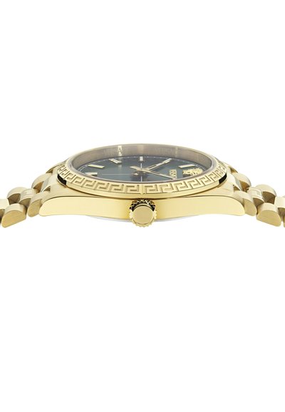 Zelta tonis pulkstenis ar melnu ciparnīcu, rakstainu rāmīti un teksturētu siksnu. Iezīmē izteiktu kroni un pulētu apdari.