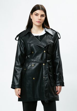 Sort læder trench coat med dobbeltknapning, store revers, guldknapper og et matchende bælte, der er bundet i taljen.
