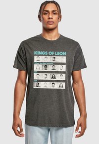 Black heather T-shirt featuring the text "KINGS OF LEON" and "When You See Yourself" above a grid of monochrome portraits.
