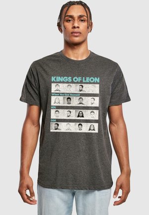 Black heather T-shirt featuring the text "KINGS OF LEON" and "When You See Yourself" above a grid of monochrome portraits.