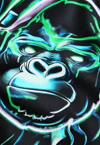 Grafica che presenta il volto di un gorilla in vivaci toni di blu e verde su uno sfondo nero, con dettagliato lavoro di linee e caratteristiche espressive.