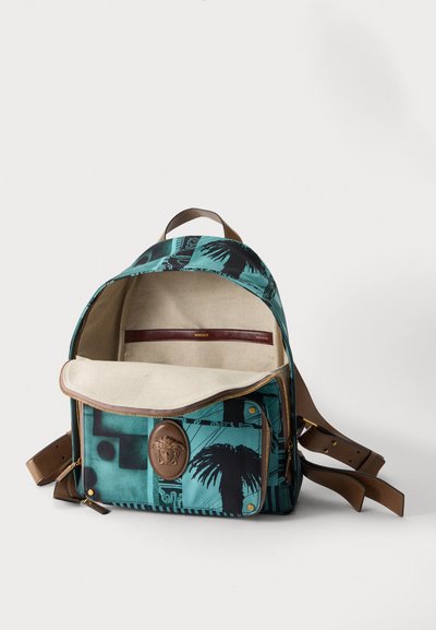 Sac à dos à motif turquoise et noir avec des bretelles en cuir marron, poche avant avec un emblème Méduse et intérieur beige avec étiquette Versace à l'intérieur.
