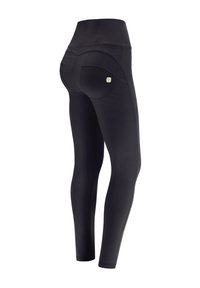 Leggings neri con vita alta, dotati di tasche posteriori curve e un tessuto morbido e elasticizzato. Dettagli cuciti lungo le cuciture.