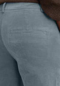 Lichtblauwe corduroy broek met een gestructureerd oppervlak. Ze hebben een enkele achterzak en een rechte pijp. Zachte, matte afwerking.