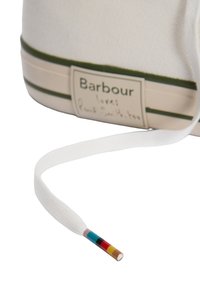 Λευκό ύφασμα αθλητικό παπούτσι με ετικέτα "Barbour" και άκρο κορδονιού που διαθέτει πέντε χρωματικές λωρίδες: τιρκουάζ, μαύρο, κόκκινο, κίτρινο και καφέ.