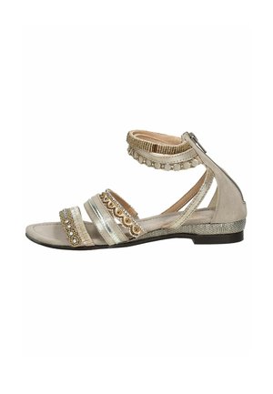 Beżowe sandały z metalicznymi akcentami, wieloma paskami, teksturowanymi materiałami, dekoracyjnymi zdobieniami i płaską podeszwą. Widok z boku.