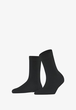 Chaussettes noires dotées d'un motif en chevrons texturé. Longueur mi-mollet avec un orteil et un revers renforcés, fabriquées à partir d'un matériau flexible et respirant.