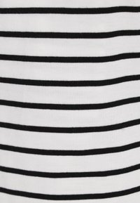 Tessuto a strisce bianche e nere, con linee orizzontali uniformi. La texture è liscia con una leggera elasticità.