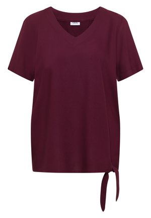 Blouse bordeaux à manches courtes avec col en V et détail noué sur le côté, en tissu lisse.