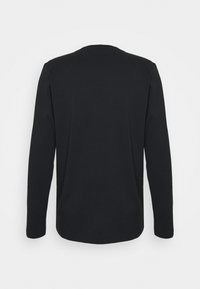 Czarna koszulka z długim rękawem, z okrągłym dekoltem, wykonana z miękkiej bawełny, cechująca się gładką fakturą i prostym krojem bez zdobień.