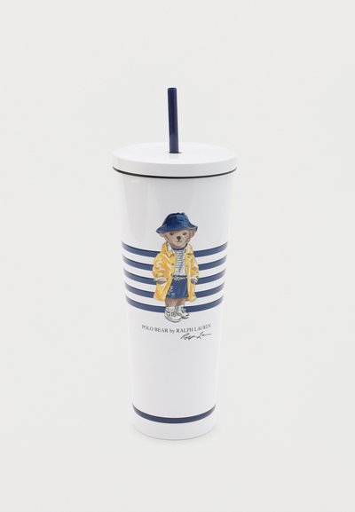 Λευκό ποτήρι με μπλε καπάκι και καλαμάκι, με εικόνα αρκούδας που φοράει κίτρινο μπουφάν, ναυτικά καπέλο και σορτς με μπλε ρίγες.