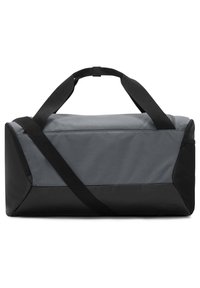 Sac de sport gris et noir en tissu durable. Doté d'une sangle réglable et de poignées renforcées pour un transport facile.