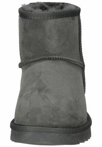 Stivaletto da caviglia in suede grigio con un interno morbido e peloso, punta rotonda e dettagli di cucitura testurizzati lungo le cuciture. Suola in gomma nera.