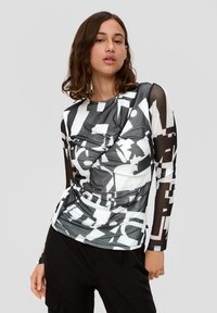 Langmouw top met een zwart-wit abstract patroon; heeft een geplooid ontwerp aan de voorkant en doorschijnende mesh-mouwen.