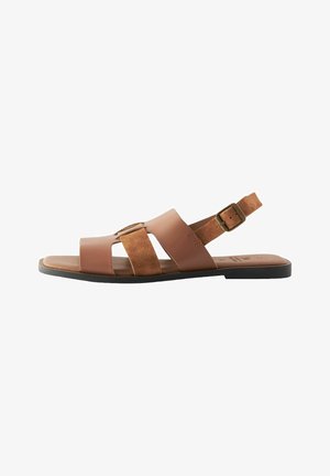 Bruine leren en suède sandalen met een open teenontwerp, verstelbare enkelriem en een gestructureerde zool. Plat met meerdere kruisslierten.