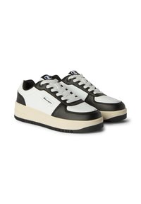 Low-top Champion sneakers in black and white with white laces, beige sole, and brand logos on the side and tongue.