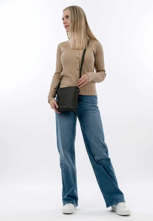 Beige ribbed sweater with button details, paired with light blue wide-leg jeans and white sneakers, carrying a small black crossbody bag.