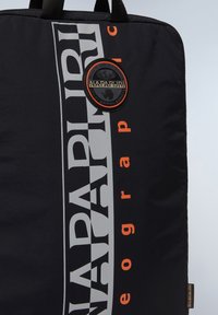 Sort nylon taske med stort hvidt og orange tekst, en rund sort logo-patch, og solide sorte håndtag. Glat, holdbar tekstur.