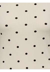 Crèmewit patroon top met zwarte polka dots, geribbelde textuur en een figuurvolgende pasvorm. Geschikt voor casual dragen.