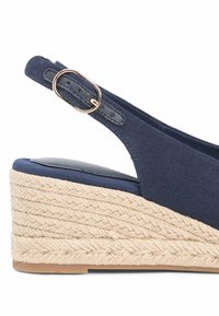 Sandalo con zeppa blu navy con cinturino alla caviglia, fibbia dorata e suola piattaforma in corda intrecciata.