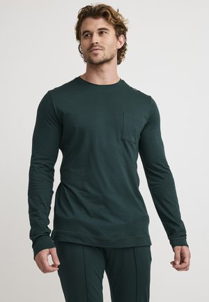 Langärmliges, dunkelgrünes Hemd aus weichem Stoff, mit Rundhalsausschnitt und einer Brusttasche, enganliegenden Ärmeln und einem lässigen Schnitt.