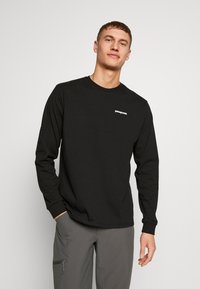 Langærmet sort bomulds T-shirt med rund hals og hvidt logo på brystet, med en afslappet pasform og standard manchetter.