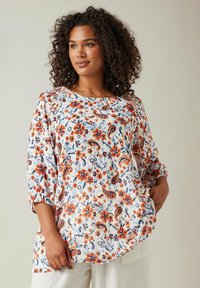 Bluse i let materiale med blomsterprint, rund halsudskæring, 3/4 ærmer og en afslappet pasform. Farverne inkluderer blå, orange og hvid.