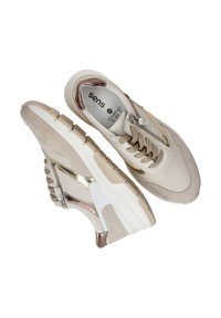 Beige sneakers met suède en leren materialen, metallic accenten, een witte tussenzool, gestructureerde rubberen zolen en een vetersluiting met rits.