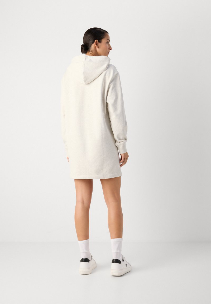 Hoodie jurk in lichtbeige, met lange mouwen, een zachte textuur en een ontspannen pasvorm, die eindigt boven de middenbovenbeen.