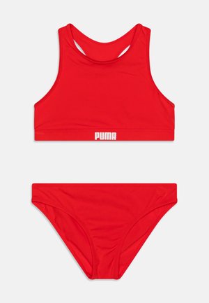 Rød bikini-sett med sportstopp og lavt skjørt. Laget av glatt stoff, med Puma-logoen i hvitt på toppbåndet.