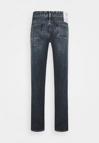 Jeans en denim bleu foncé avec une coupe droite, dotés de poches arrière et d'une étiquette à la taille. Texture mate, avec un minimum de décoloration et des détails de couture.