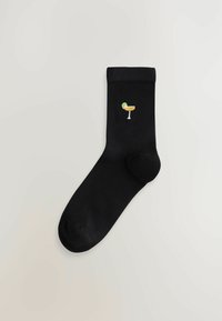 Mustad mustas sokid, millel on siledat tekstuuri ja kuhu on brodeeritud erksavärviline kokteiliklaas.