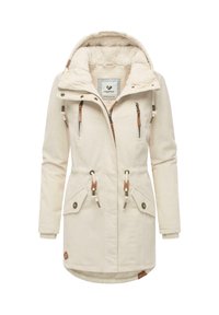 Parka color crema con cappuccio foderato in pile, chiusura con zip e bottoni, numerose tasche con zip e vita regulabile con cordino. Presenta una texture a coste.