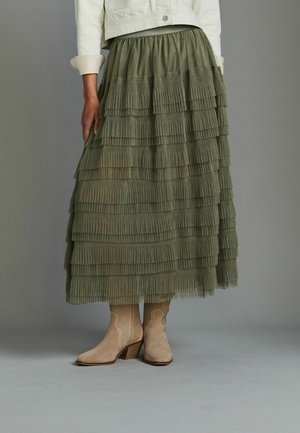 Olijfgroene tiered maxi rok met plooien, met een aansluitende tailleband en een luchtig, gestructureerd ontwerp. Gepaarde met beige suède haklaarzen.