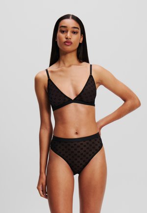 Black bralette and high-waisted brief set made of sheer fabric with a repeating geometric pattern and adjustable straps.