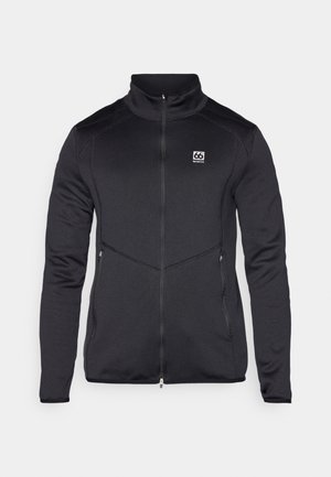 Zwarte softshell jack met hoge kraag, ritssluiting aan de voorkant, zijzakken en logo-detail op de linker borst. Ontwerp met rekbare stof.